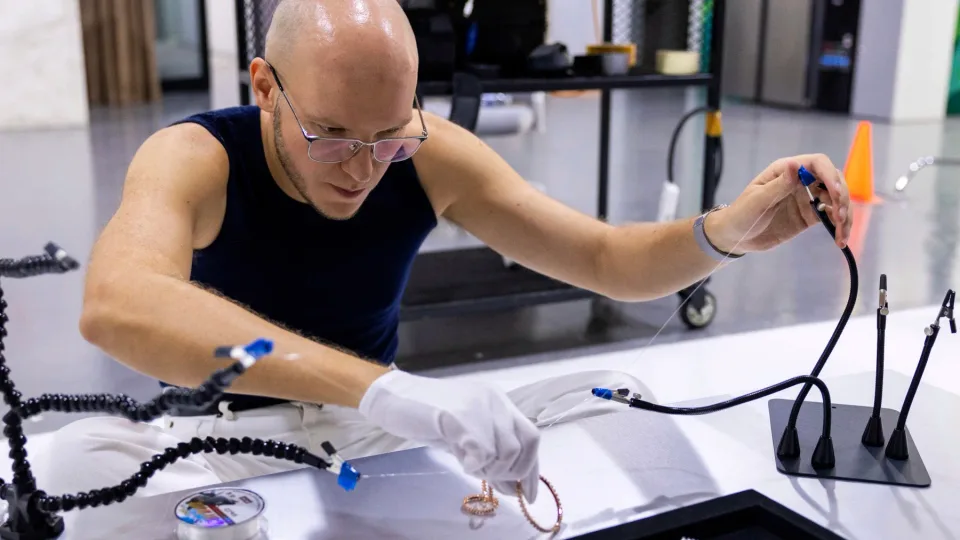 Dmitrii Kitavin arranging jewellery beneath studio rigging