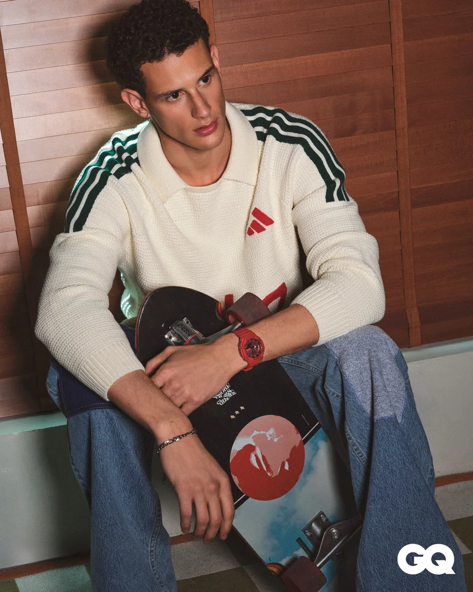 A seated model holds a table-tennis paddle and wears a Casio watch beside wood panelling.