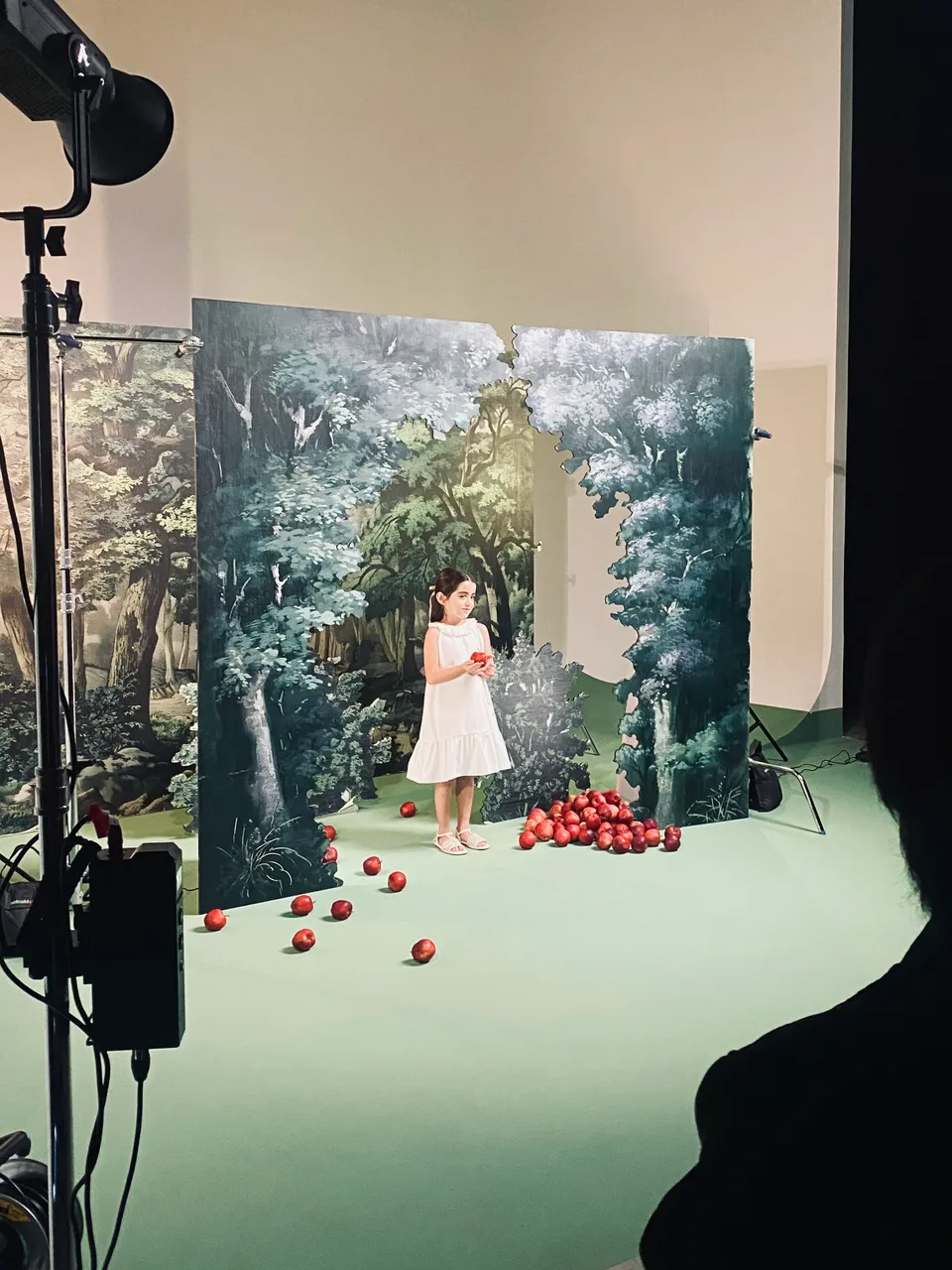 Behind the scenes of a model on the layered forest set for Disney × Razan Alazzouni.