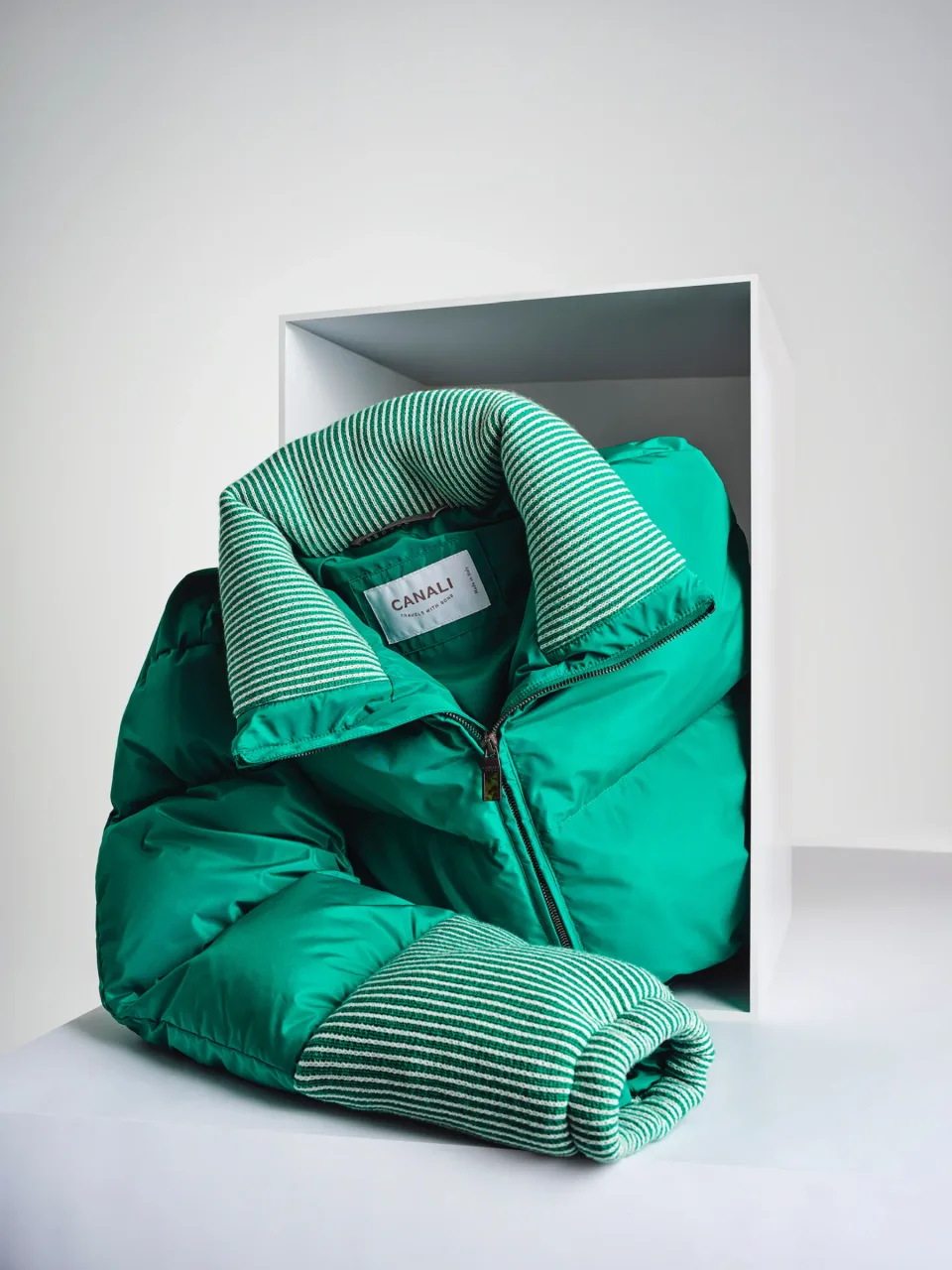 Green Canali jacket and striped knitwear arranged in a white display frame