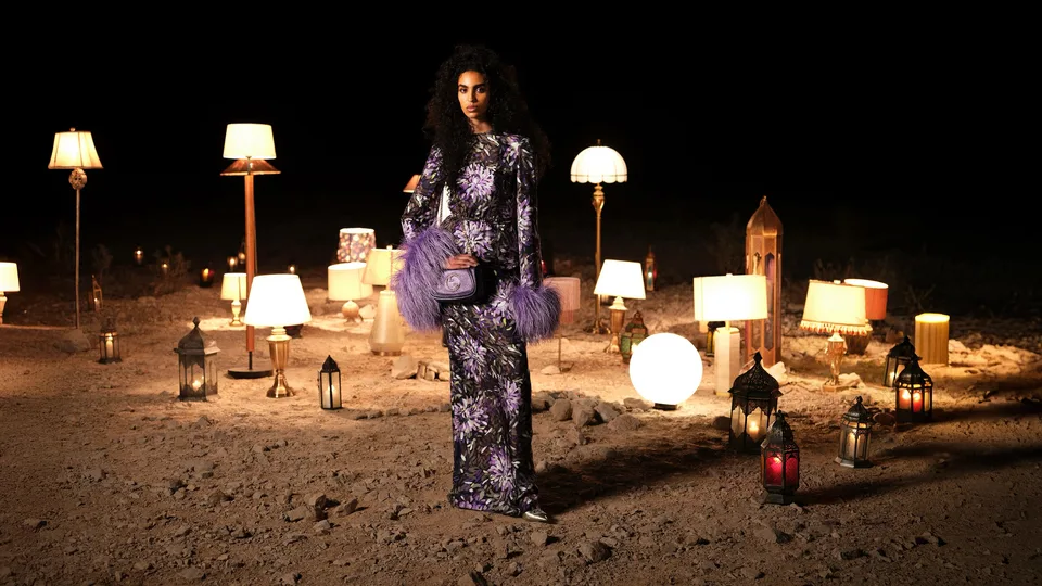 Gucci Nojum campaign: a model in a purple floral outfit among lamps and lanterns at Jebel Jais