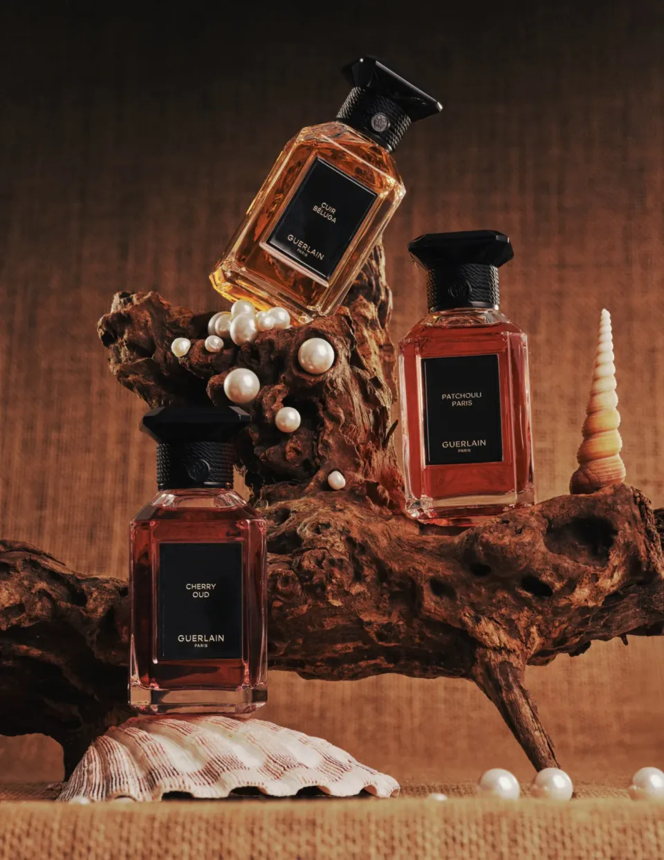 Three Guerlain perfume bottles with pearls, shells and driftwood