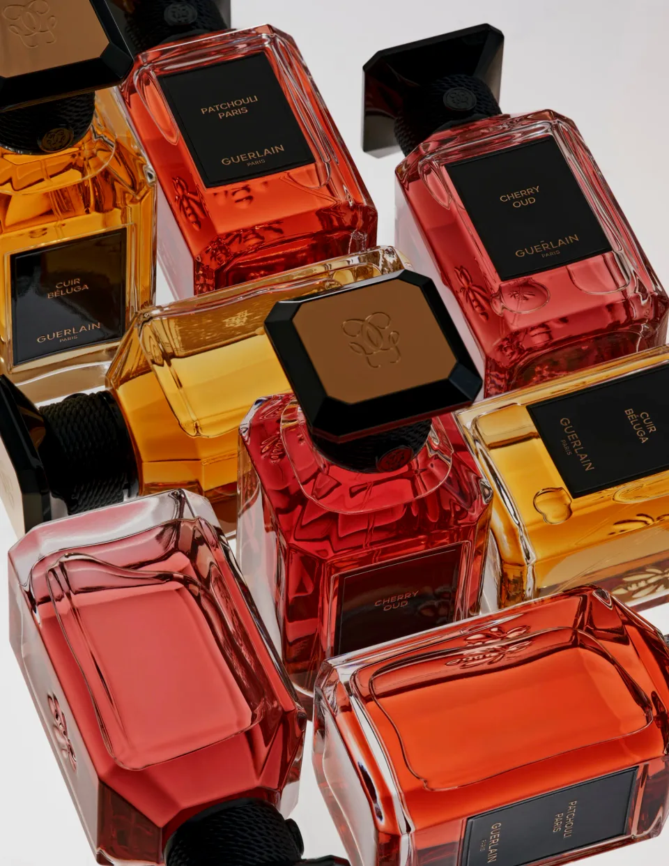 Overlapping Guerlain perfume bottles on a white background