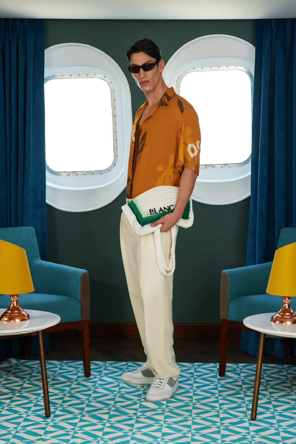 Person between two round windows, blue curtains and armchairs