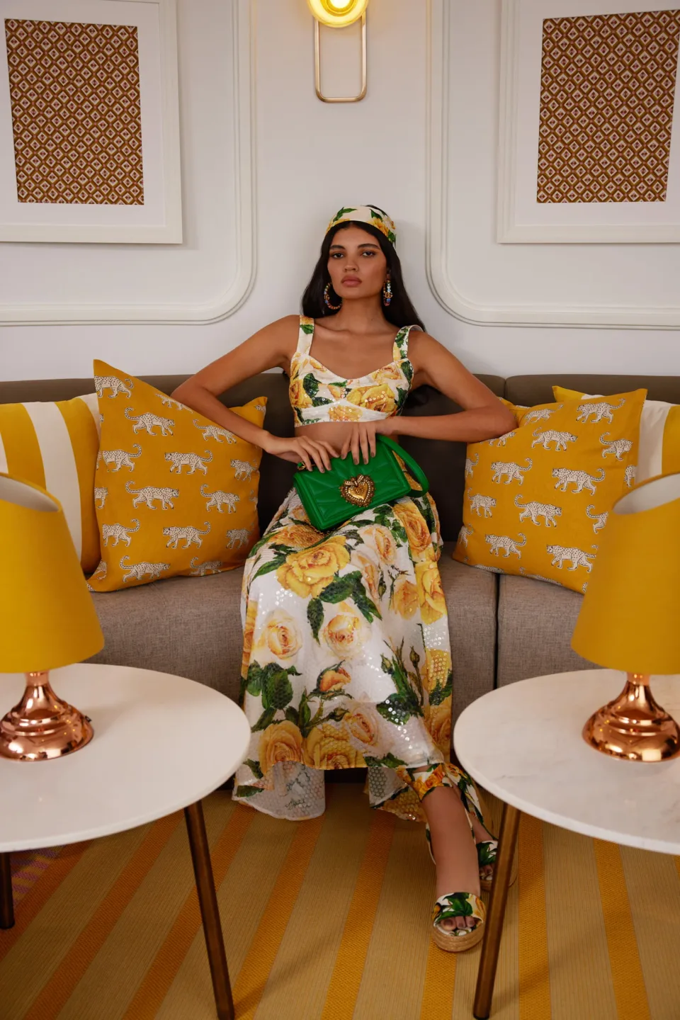 Person seated on a sofa between yellow lamps