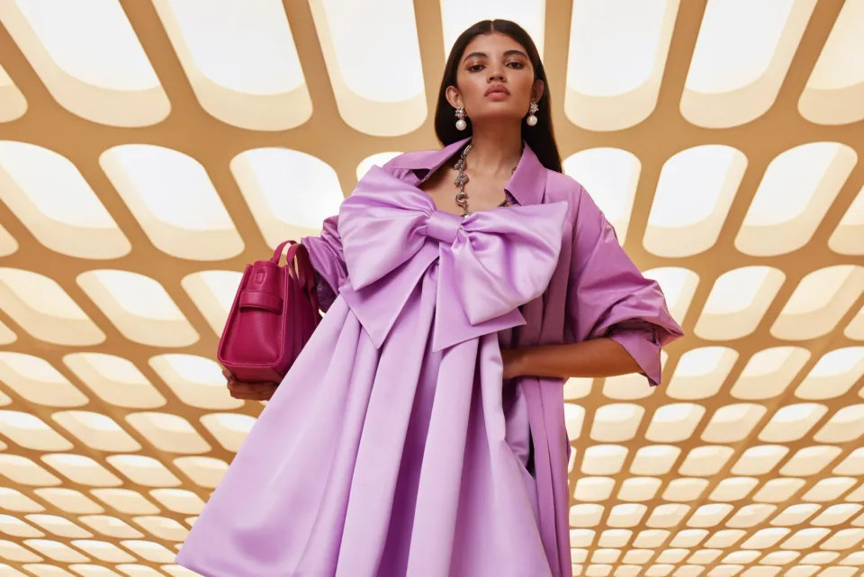 Person wearing a lilac outfit beneath a patterned ceiling