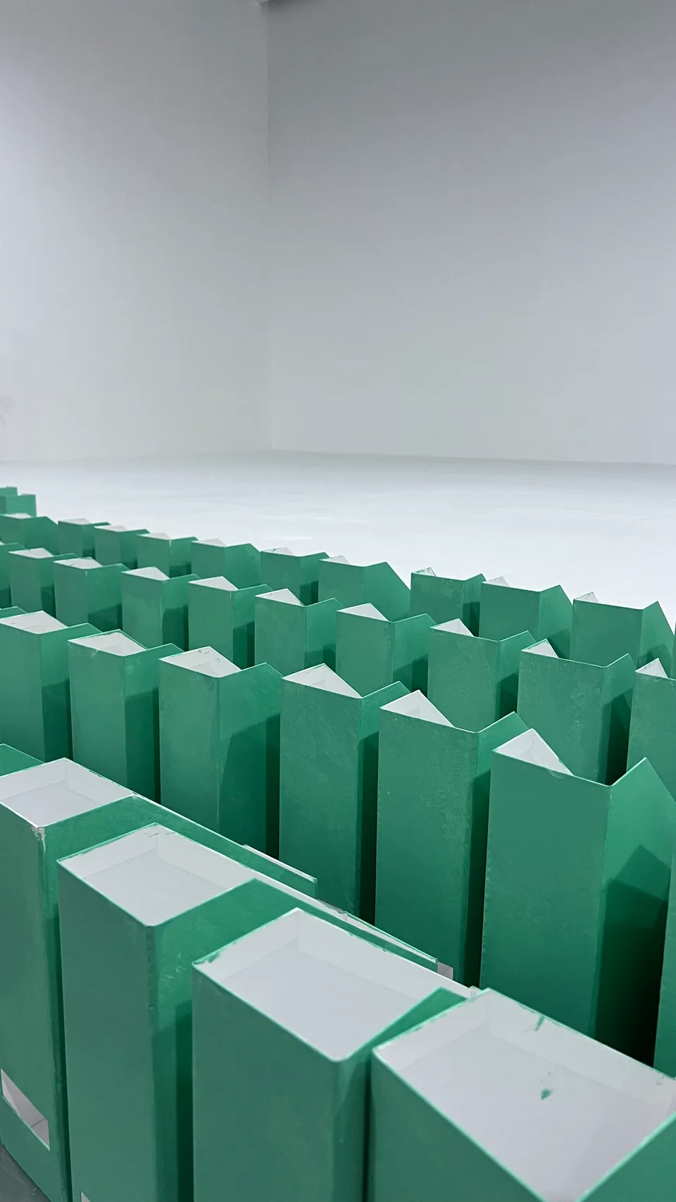 Rows of green folder-shaped scenic props prepared for the office set.