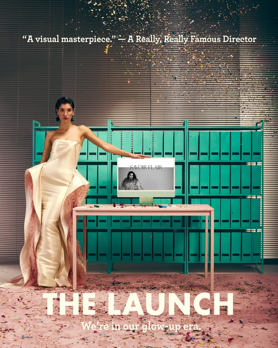 Savoir Flair launch image: a model in a cream dress sits on the office desk beneath falling confetti.