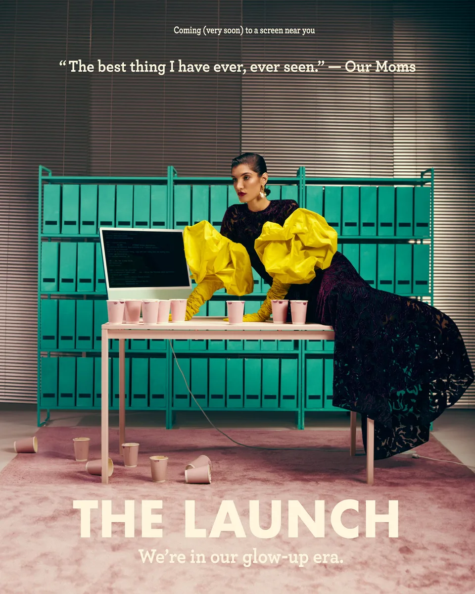 Savoir Flair launch image: a model in black and yellow sits at a pink desk in front of rows of green folders.