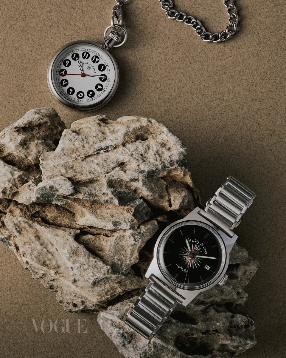 A pocket watch and wristwatch are arranged around a rough pale stone.