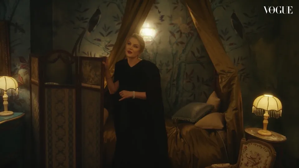 A Vogue film frame showing the interview in an upholstered bed alcove.