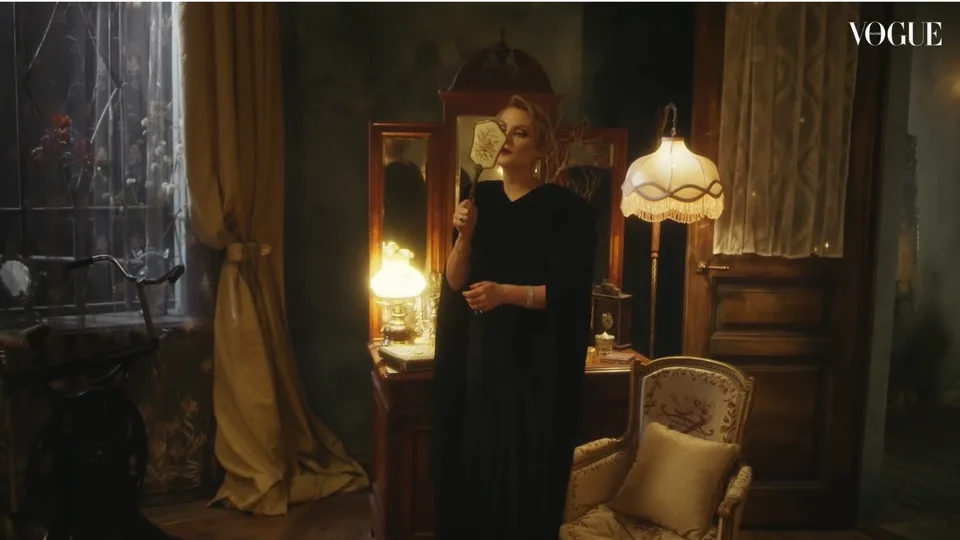 Frame from Vogue’s 33 Questions showing an interview beside a fireplace.